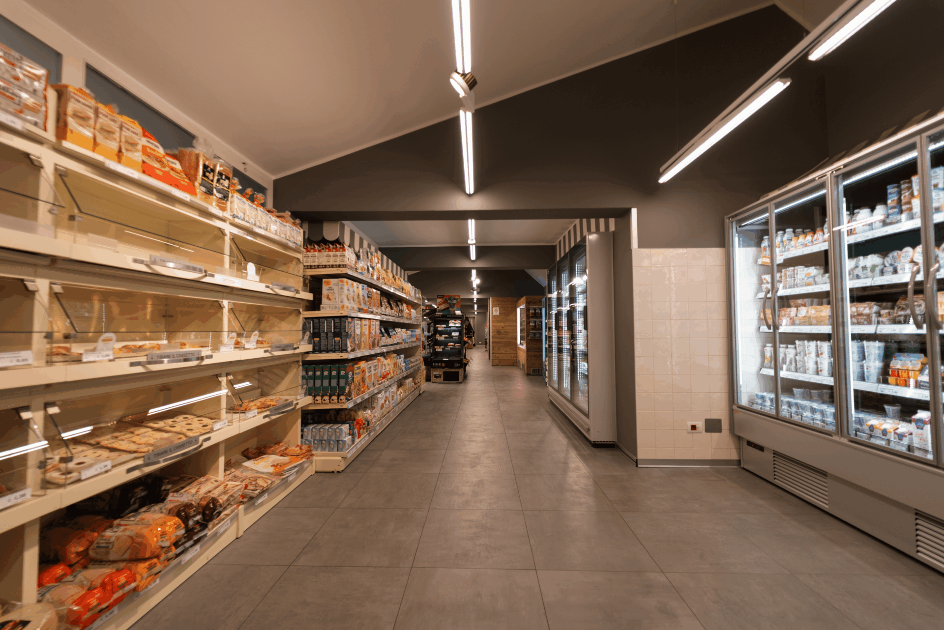 Corsia del supermercato del Camping Dei Fiori con prodotti confezionati e frigoriferi.