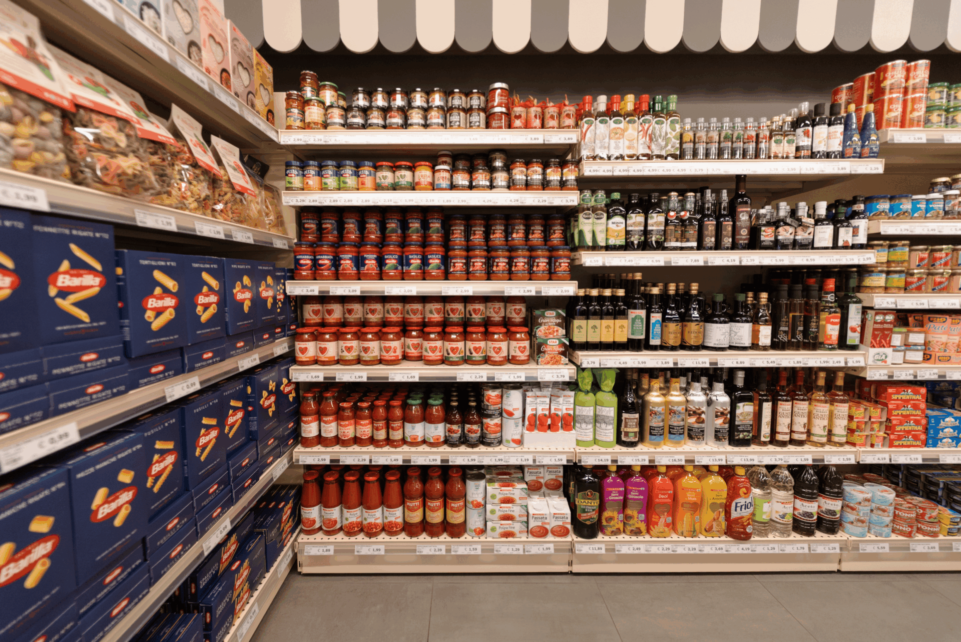 Scaffali con pasta, conserve, condimenti e prodotti italiani nel supermercato del Camping Dei Fiori.