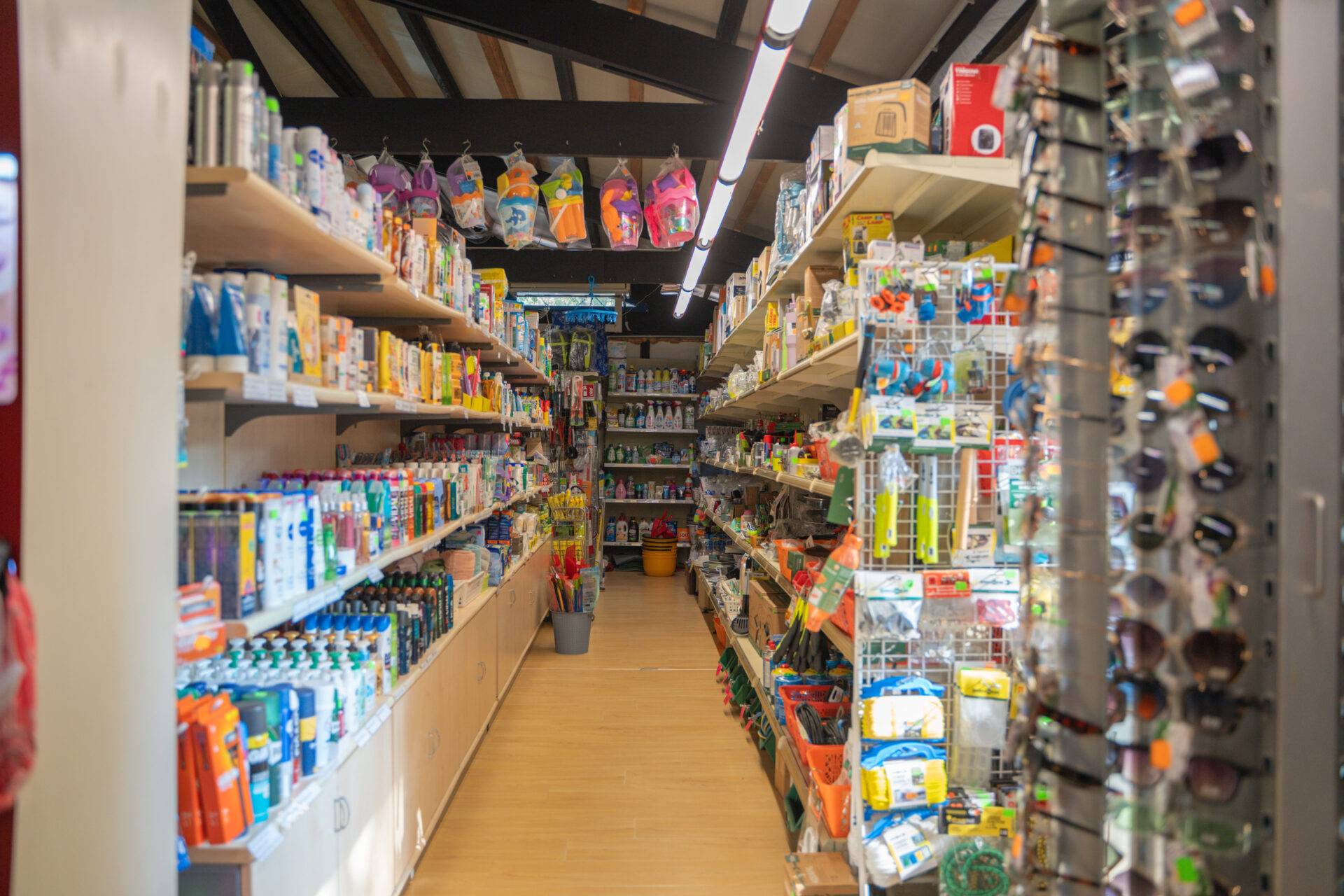 Corsia del bazar con prodotti per la persona e accessori da campeggio al Camping Village Dei Fiori.