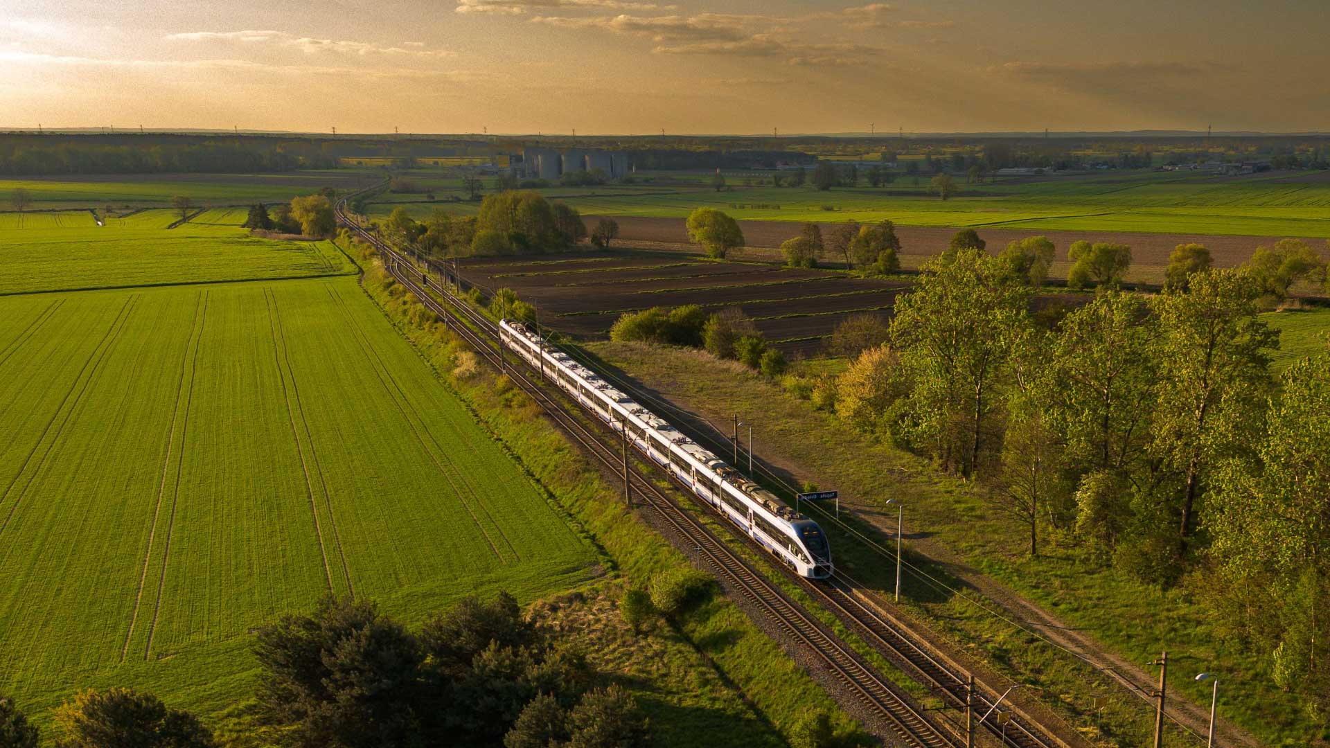 Treno in viaggio tra campi verdi per raggiungere il Camping Village Mediterraneo a Cavallino-Treporti.