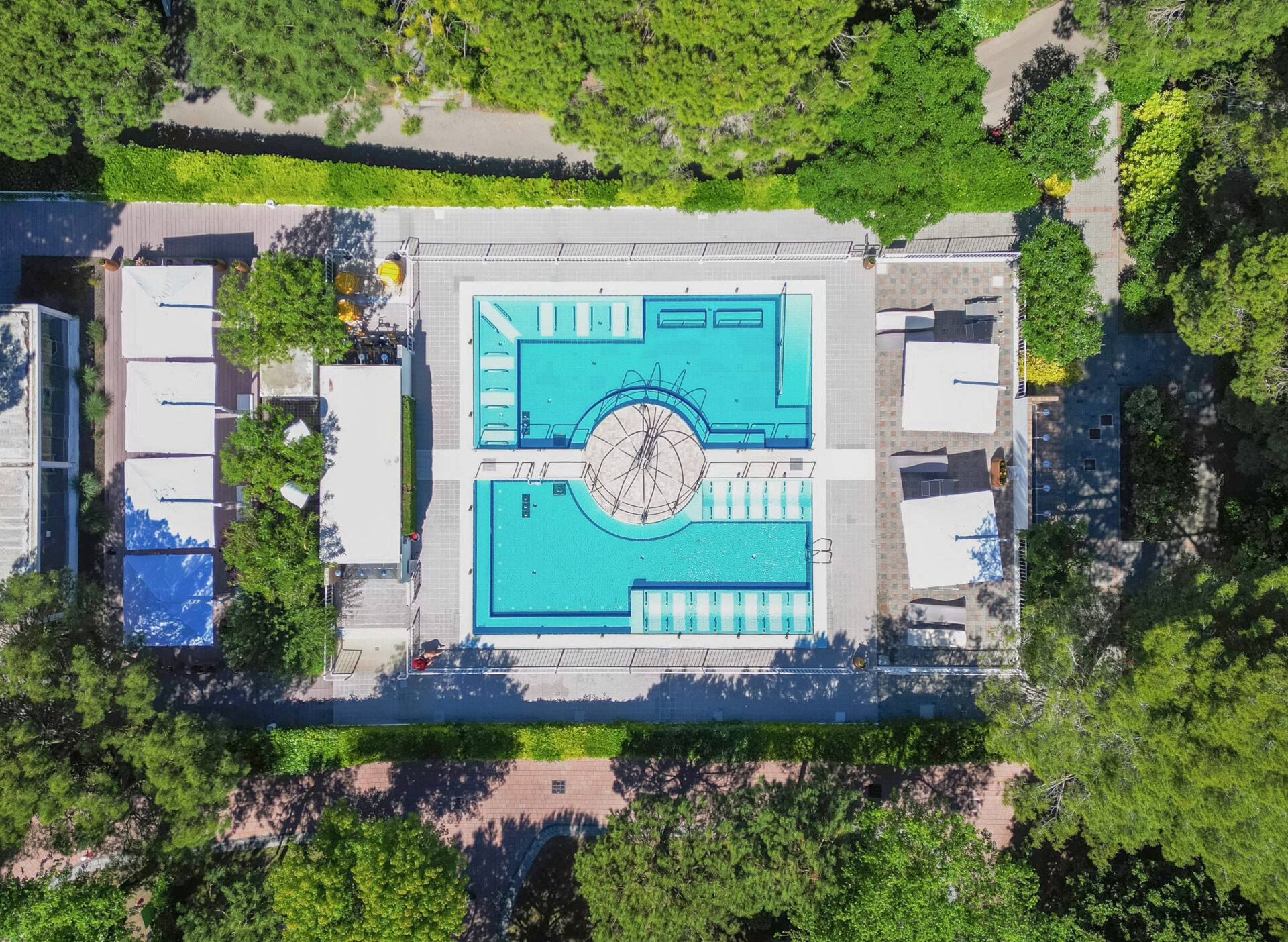 Vista dall'alto della piscina idromassaggio del Camping Dei Fiori, con postazioni a getto d'acqua e solarium.
