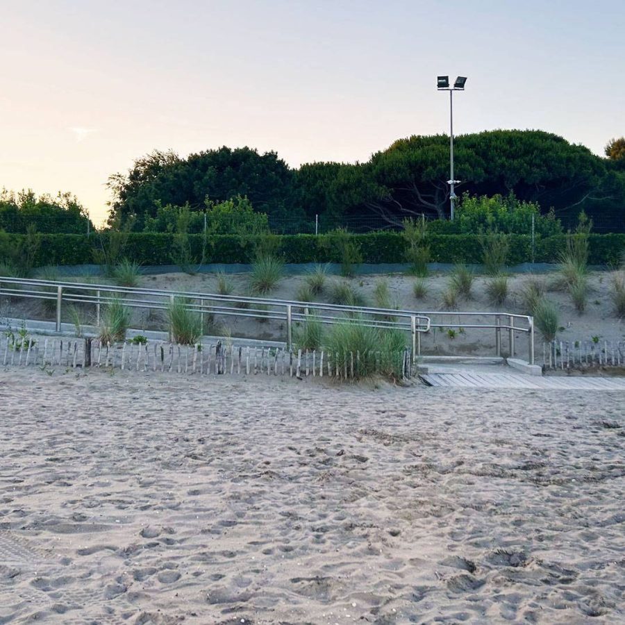 Passerella con corrimano attraversa le dune sabbiose e la vegetazione costiera presso la spiaggia del Camping Dei Fiori.